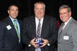 With Mr. Gronefeld, center, as he accepts the award are Better Business Bureau Board Chairman Mike Anderson, left, and Better Business Bureau President and CEO Charlie Mattingly.