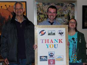 Todd Hill, far left, and Amanda Goss, who receive services through ResCare Residential Services’ Community Advantage, presented Governor’s Aide Luke Smith with a life-size thank you card created for Governor John Hickenlooper.