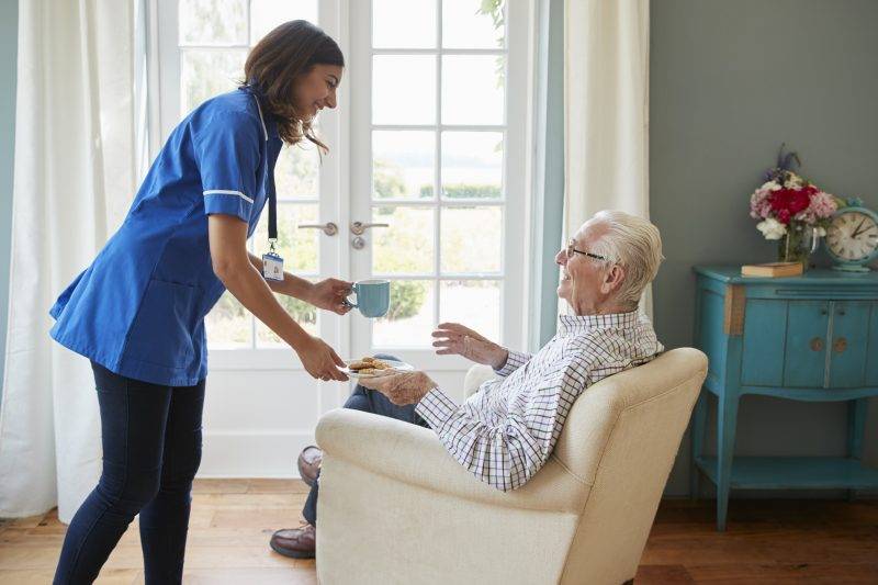 caregiver serving elderly man