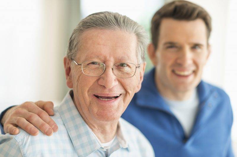 caregiver hugging elderly man