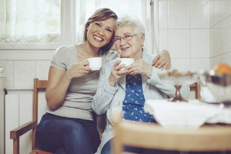 caregiver and woman drinking tea